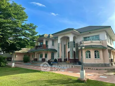 Stunning two-story mansion with elegant architecture and lush green surroundings, perfect for luxury living.