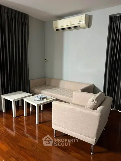 Cozy living room with modern furniture and air conditioning, perfect for relaxation.