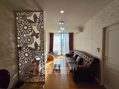 Elegant living room with stylish partition and natural light, featuring a cozy sofa and modern decor.