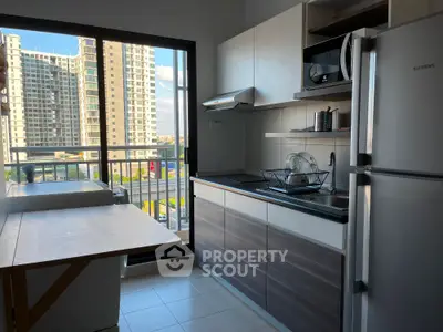 Modern kitchen with sleek appliances and balcony view in high-rise apartment