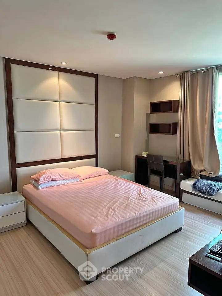 Spacious bedroom with modern decor and natural light, featuring a comfortable bed and study area.