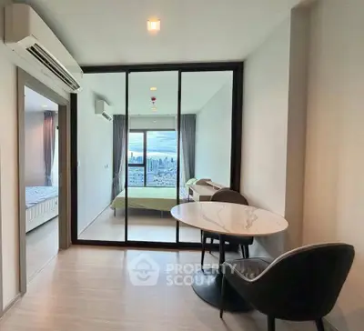 Modern apartment with city view, featuring a stylish living area and bedroom separated by glass doors.