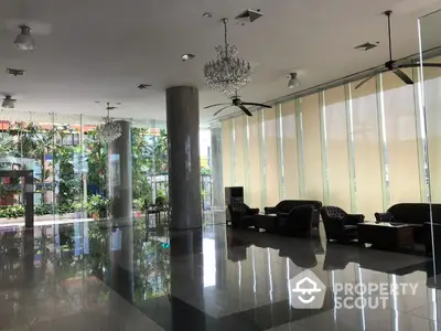 Luxurious building entrance with elegant chandeliers and modern seating area