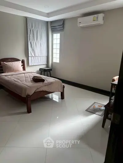 Cozy bedroom with single bed, air conditioning, and modern decor, perfect for a comfortable living experience.