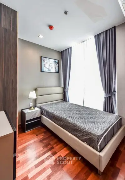 Modern bedroom with elegant decor and natural light in a stylish apartment.