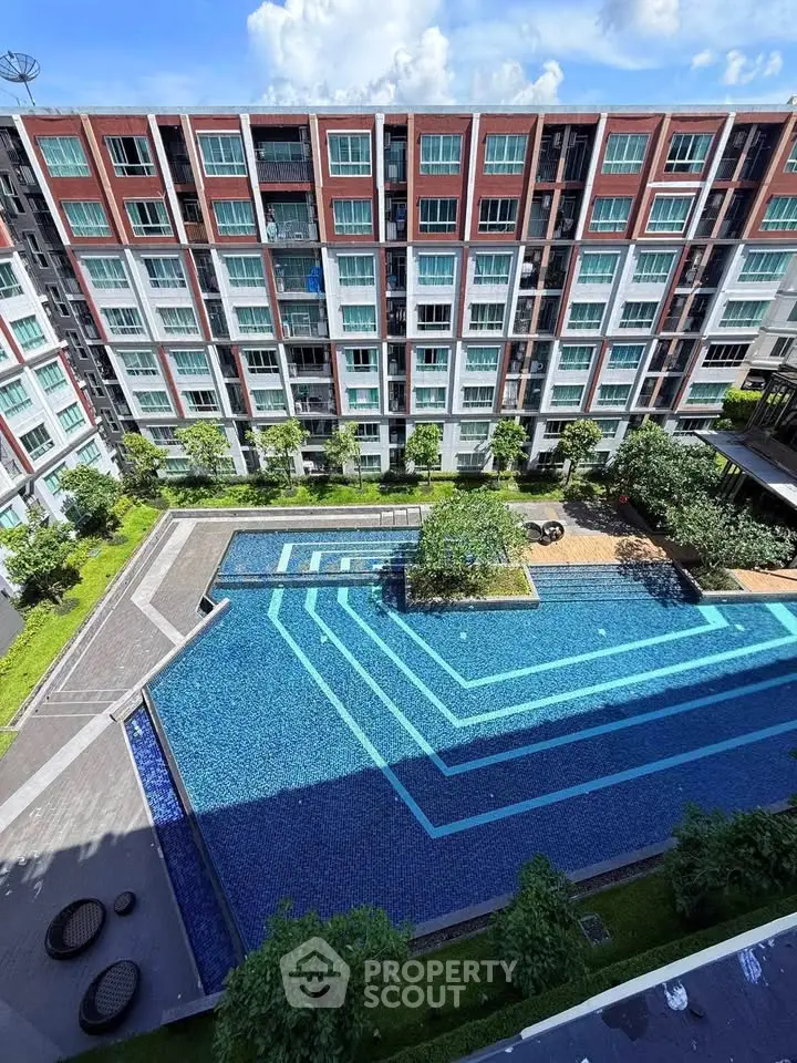 Modern apartment complex with a stunning outdoor pool and lush greenery, perfect for urban living.