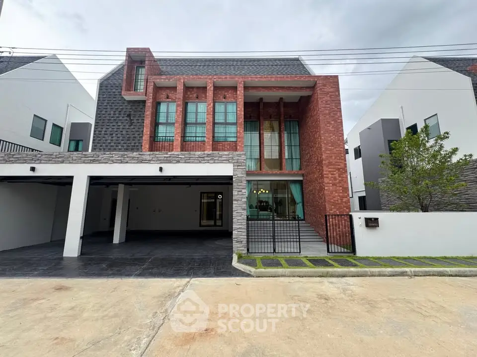 Modern two-story house with brick facade and large windows in a suburban neighborhood.