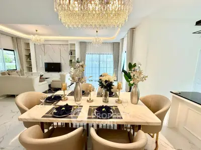 Luxurious open-plan living and dining area with elegant chandelier and modern decor