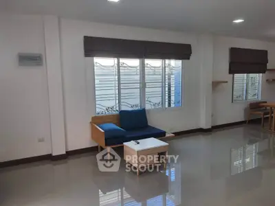 Spacious modern living room with sleek furniture and large windows for natural light.