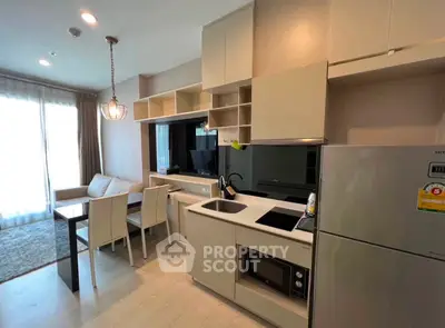 Modern open-layout kitchen and living area with sleek cabinetry and dining space.