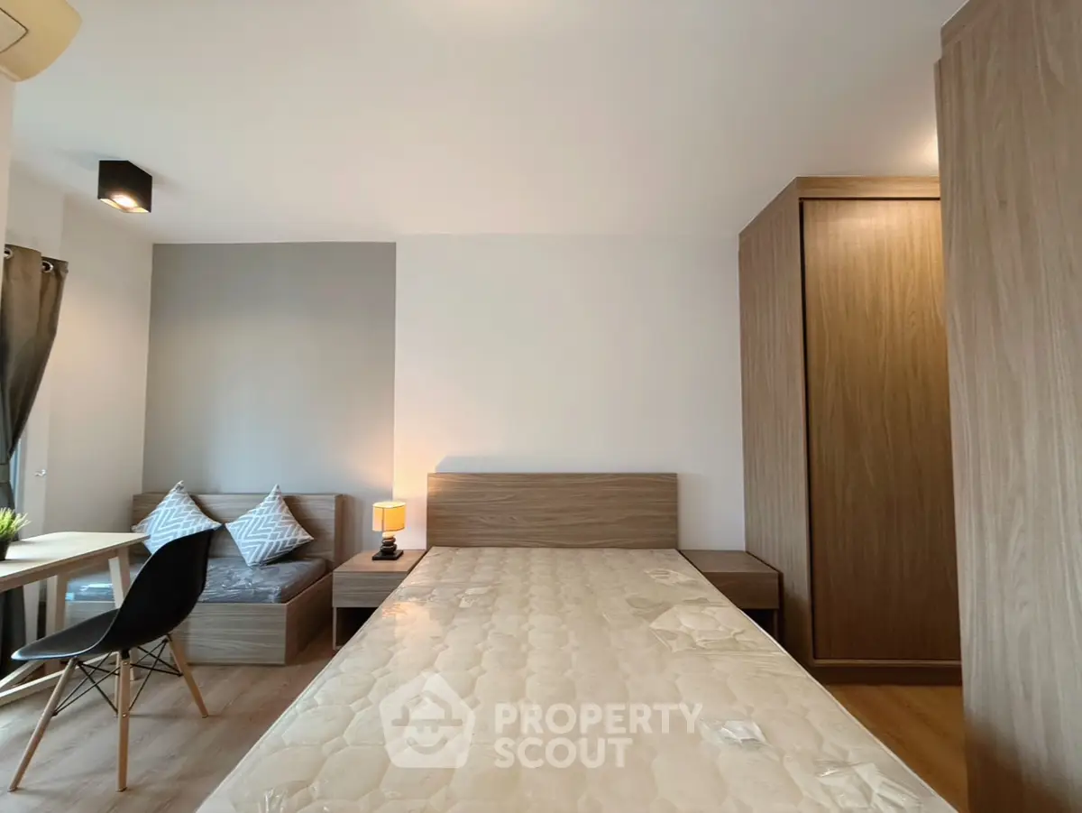 Modern bedroom with sleek wooden furniture and cozy seating area