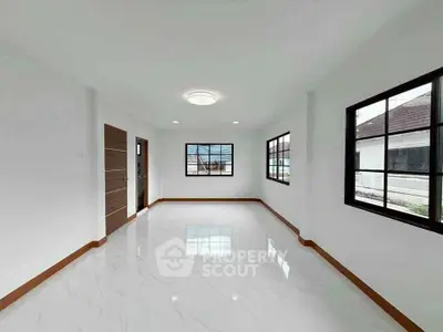 Spacious empty room with large windows and glossy white flooring