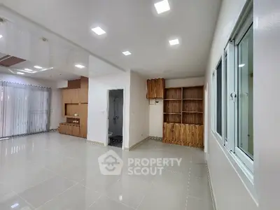 Spacious modern living room with sleek tile flooring and recessed lighting.