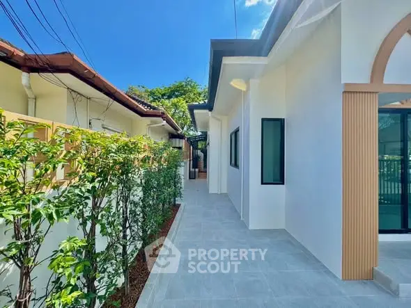 Modern exterior walkway with lush greenery and sleek architecture
