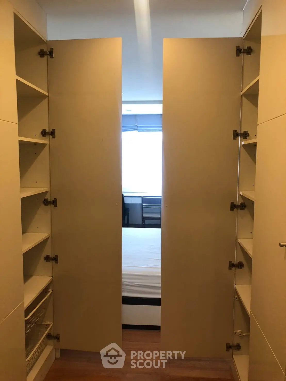 Spacious walk-in closet leading to a bright bedroom with ample storage and natural light.