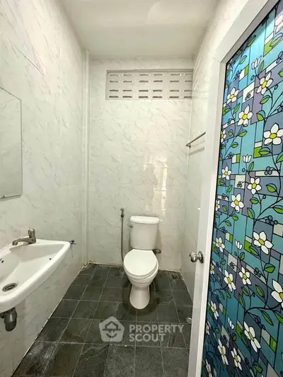 Compact bathroom with floral glass door and modern fixtures