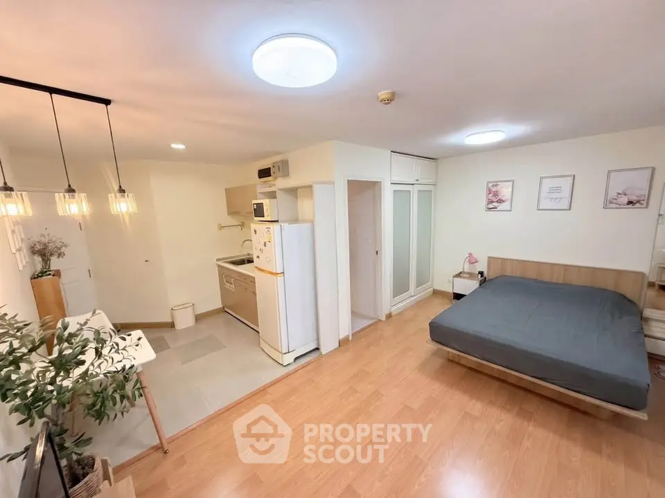 Spacious studio apartment with modern kitchen and cozy bedroom area, perfect for urban living.