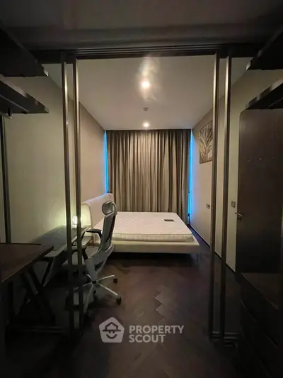 Modern bedroom with sleek design, featuring a comfortable bed and stylish workspace, perfect for urban living.