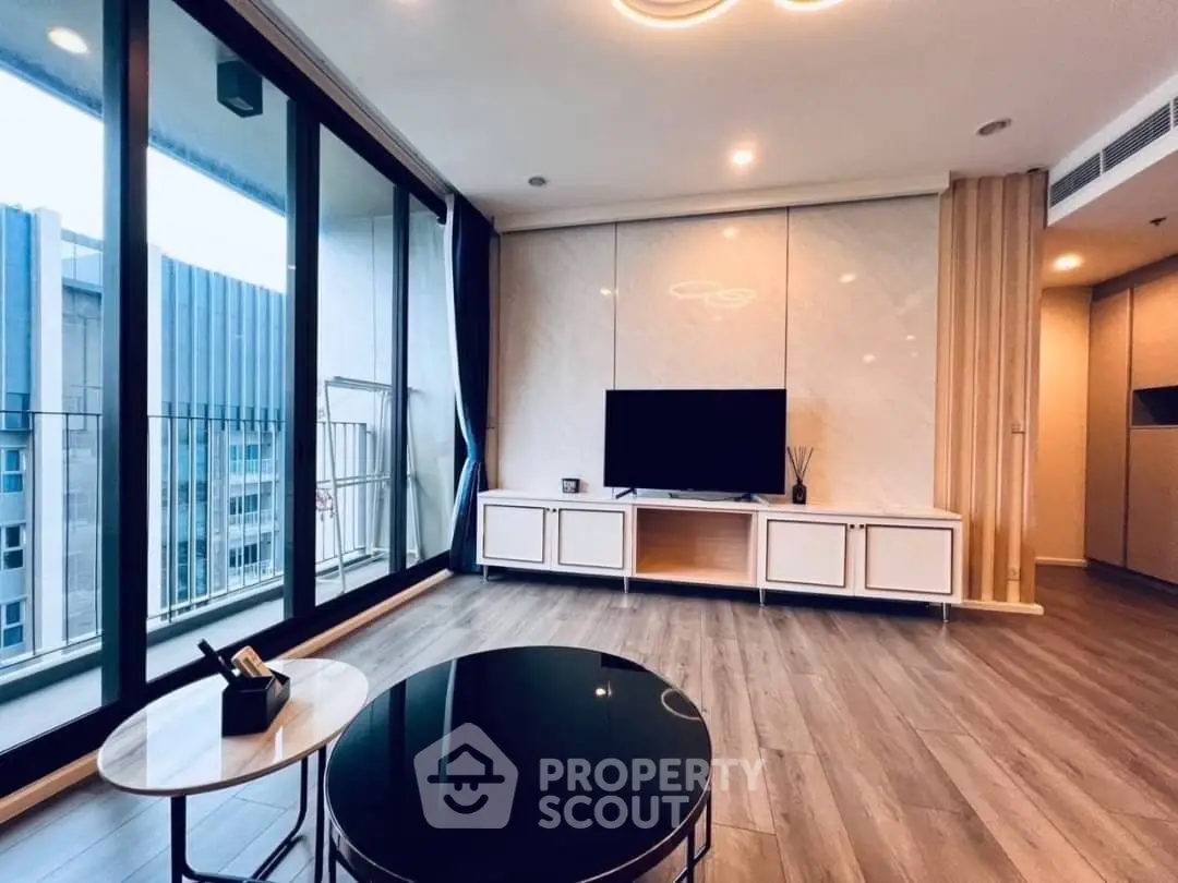 Modern living room with sleek design and large windows offering city views.