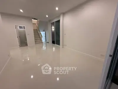 Spacious modern interior with glossy floors and staircase, ideal for contemporary living.