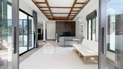 Spacious modern living room with large windows and stylish ceiling design