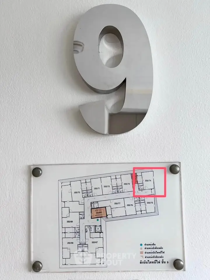 Floor plan on wall with large number nine, highlighting specific unit in building layout.