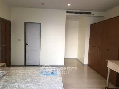 Spacious bedroom with wooden wardrobe and modern decor in a cozy apartment.