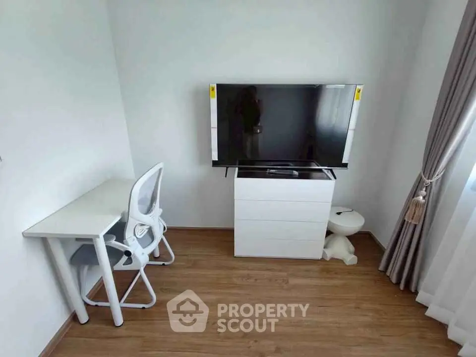 Modern study room with sleek desk, chair, and mounted TV for a stylish home office setup.