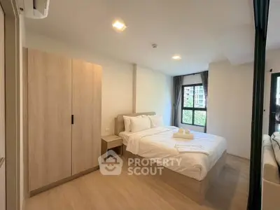 Modern bedroom with natural light and minimalist decor in a stylish apartment.