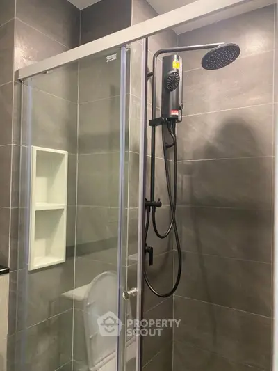 Modern bathroom with sleek shower and glass enclosure, featuring elegant tile design.