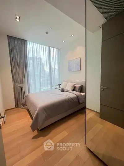 Luxurious modern bedroom with floor-to-ceiling windows and elegant decor in a high-rise apartment.