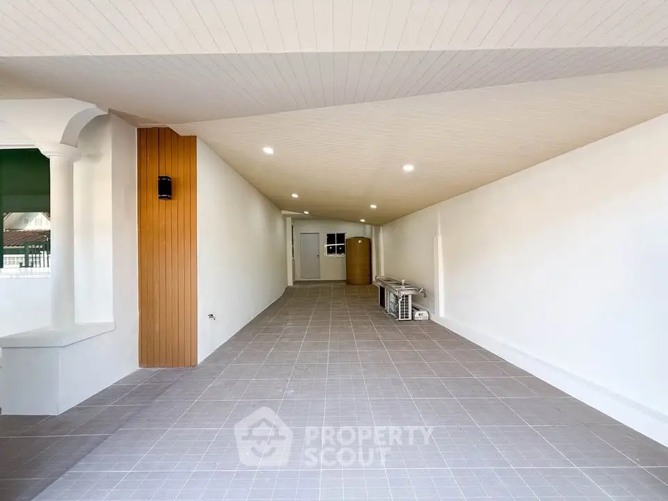 Spacious covered parking area with modern lighting and tiled flooring