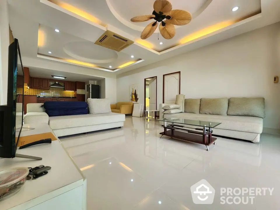 Spacious modern living room with elegant ceiling design and cozy seating area.