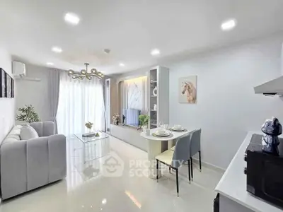 Modern living room with elegant decor and open dining area, featuring a stylish chandelier and natural light.