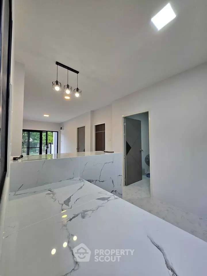 Modern kitchen with marble countertops and open layout in a bright, spacious home.