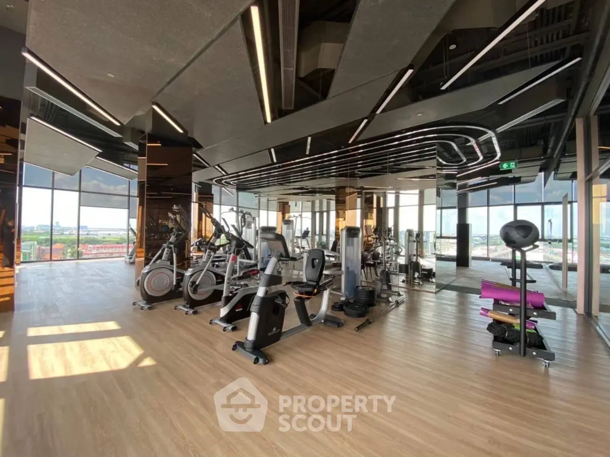 Spacious modern gym with panoramic city views and state-of-the-art equipment.