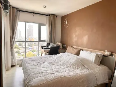 Modern bedroom with city view, featuring cozy bed and study area, ideal for urban living.