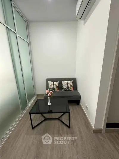 Cozy modern living room with sleek glass partition and stylish decor