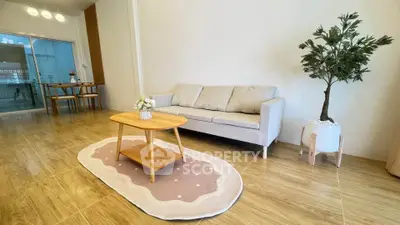 Spacious living room with modern decor and natural light, featuring a cozy sofa and stylish coffee table.