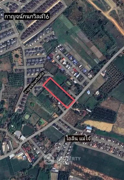 Aerial view of a residential area with a highlighted plot of land for sale.