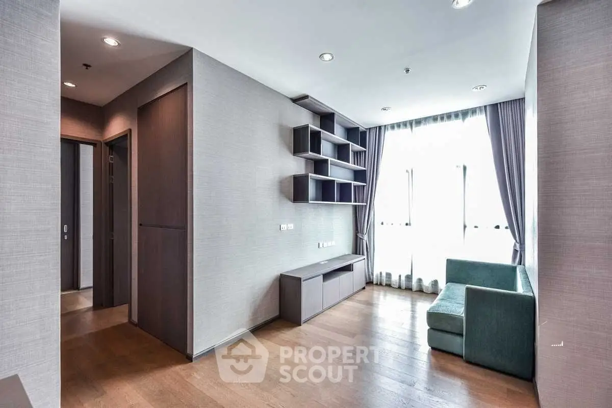Modern living room with sleek shelving and large windows for natural light.