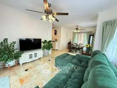 Spacious living room with green sofa and modern decor, perfect for relaxation and entertainment.