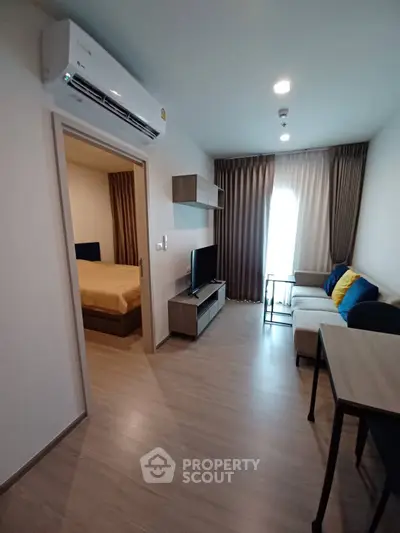 Modern living room with sleek furniture and open view to bedroom, perfect for urban living.