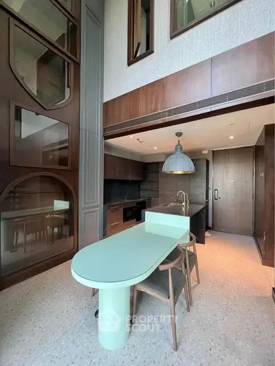 Modern kitchen with sleek design, featuring an open layout and stylish dining area.