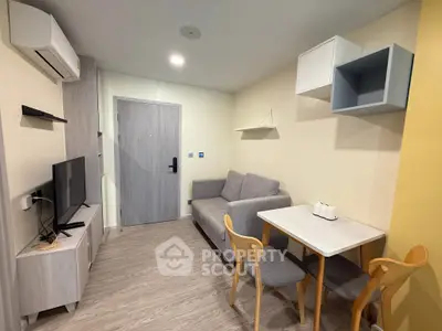 Modern living room with cozy sofa, dining table, and wall-mounted TV in a stylish apartment.