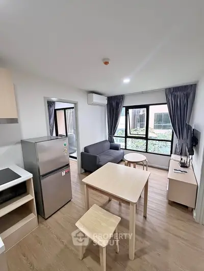 Modern living room with stylish furniture and large windows offering garden views.