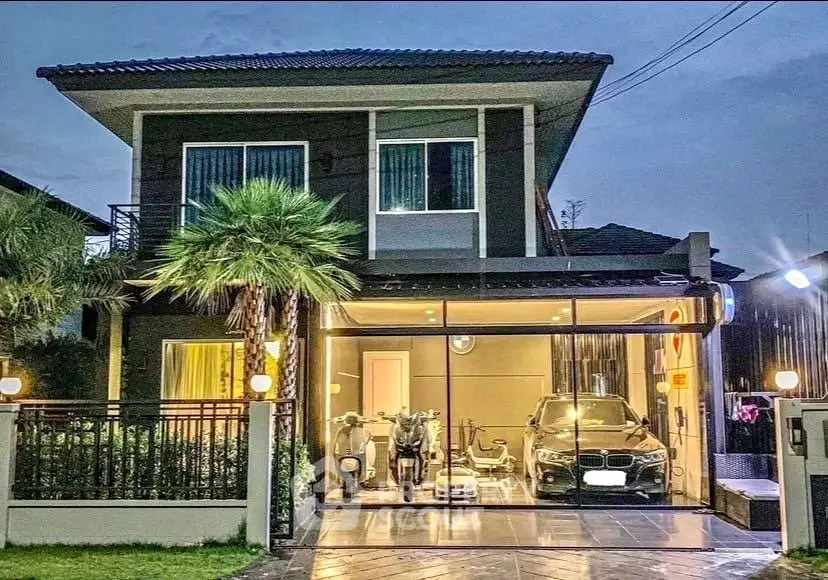 Modern two-story house with garage and palm trees at dusk