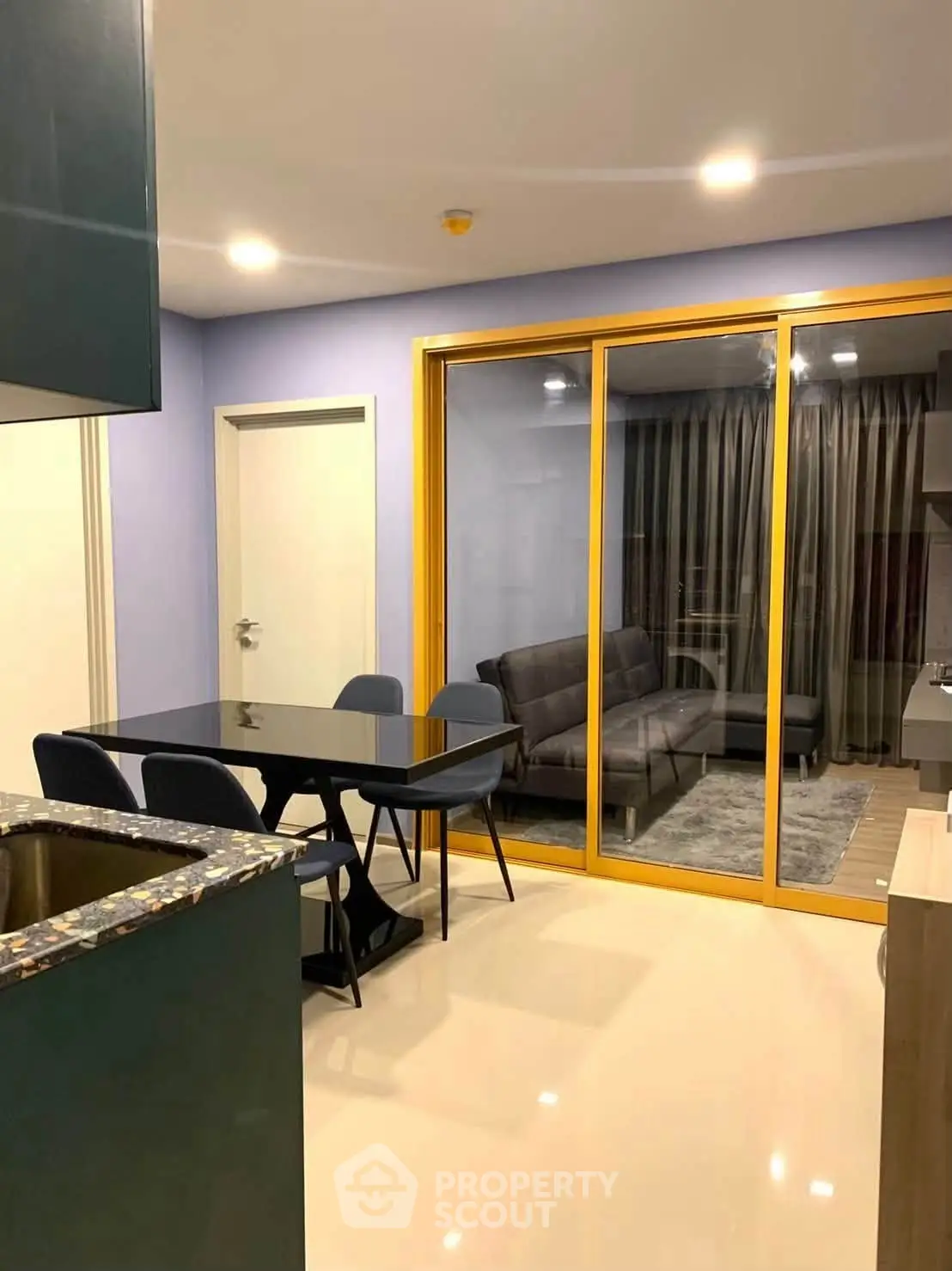 Modern open-layout kitchen and living room with sleek furniture and glass sliding doors.