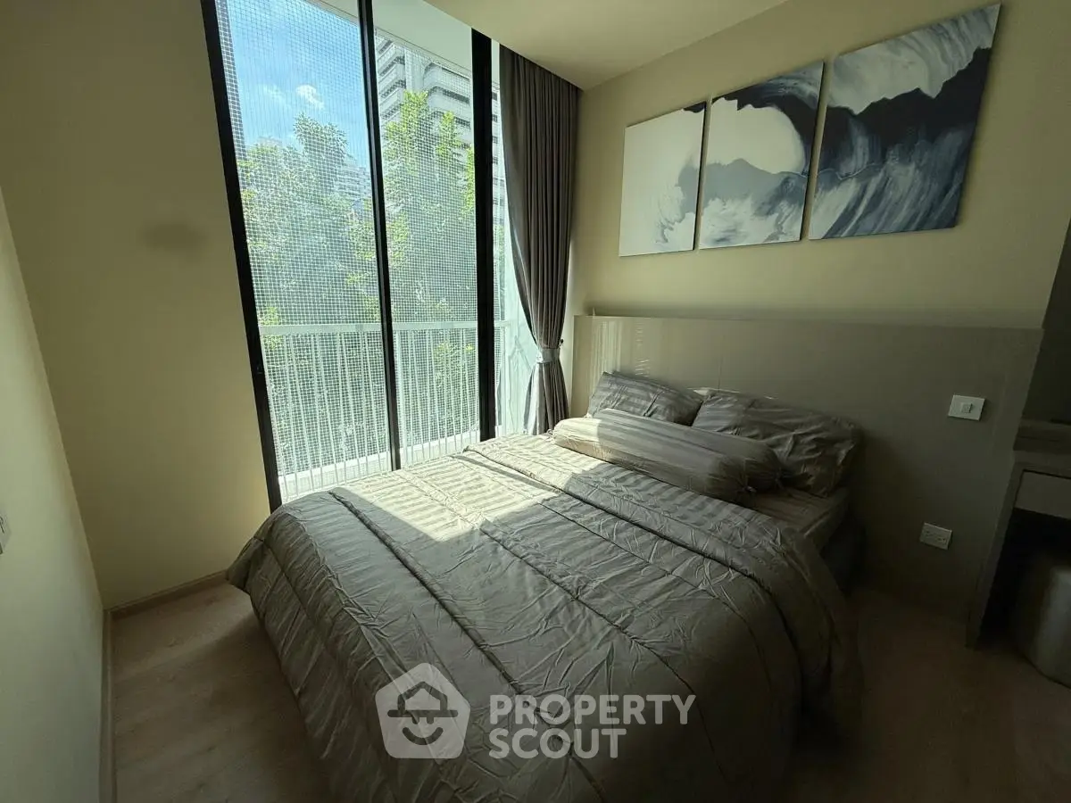 Modern bedroom with large windows and stylish decor in a high-rise apartment.