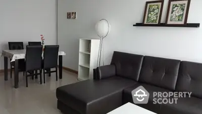 Modern living room with sleek black leather sofa and elegant dining area